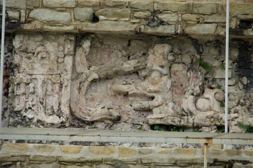 Ancient Mayan stone carving at Palenque, Chiapas, Mexico, depicting detailed relief work with symbolic figures and motifs. 