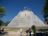 The Pyramid of the Magician at Uxmal, Yucatan, Mexico, a towering Mayan structure with steep sides and tourists at the base. 