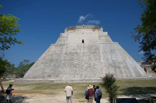 The Pyramid of the Magician at Uxmal, Yucatan, Mexico, a towering Mayan structure with steep sides and tourists at the base. 