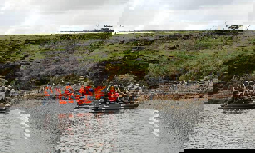 Zodiac landing near a penguin colony on the wild, green shores of southern Chile. 