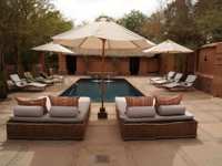 Relaxing poolside loungers and parasols in a stylish desert retreat, perfect for unwinding in Chile's Atacama region. 