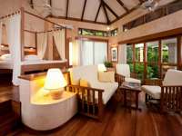 A warm, elegant suite at Capitan Suizo blends open-air luxury with natural Costa Rican style. 