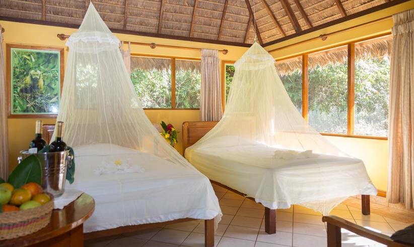Twin beds with mosquito nets in a rainforest ecolodge in Tambopata, Peru. 