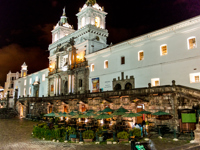 San Francisco Church glows over Quito's colonial main square at night in Ecuador. 