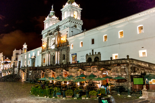 San Francisco Church glows over Quito's colonial main square at night in Ecuador. 
