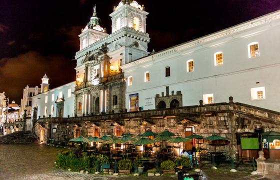 San Francisco Church glows over Quito's colonial main square at night in Ecuador. 