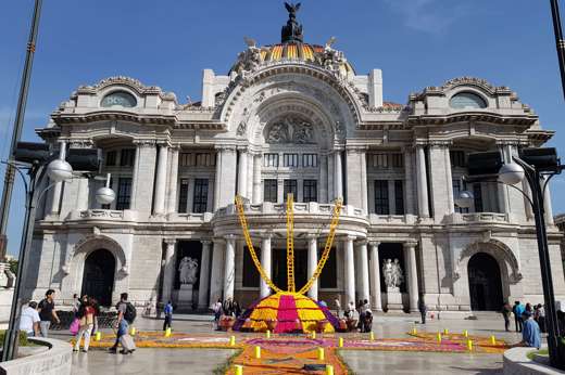 Palacio de Bellas Artes in Mexico City with Day of the Dead altar and colourful  marigold decorations in front of the entrance. 
