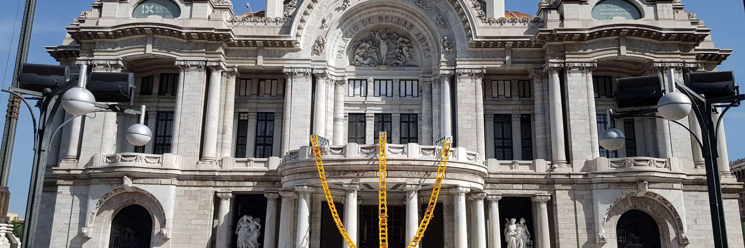 Palacio de Bellas Artes in Mexico City with Day of the Dead altar and colourful  marigold decorations in front of the entrance. 