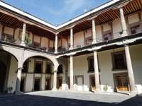 Interior courtyard of the National Palace in Mexico City, with arches, columns, and balconies surrounding the open space. 