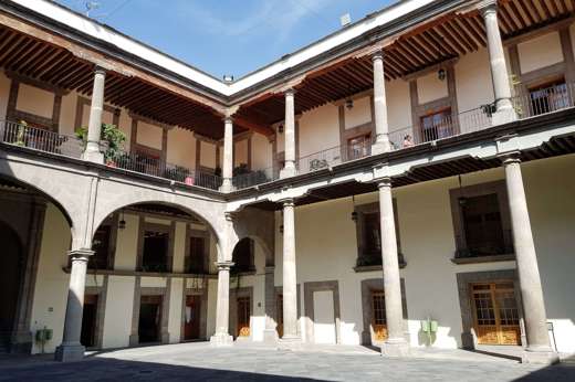 Interior courtyard of the National Palace in Mexico City, with arches, columns, and balconies surrounding the open space. 