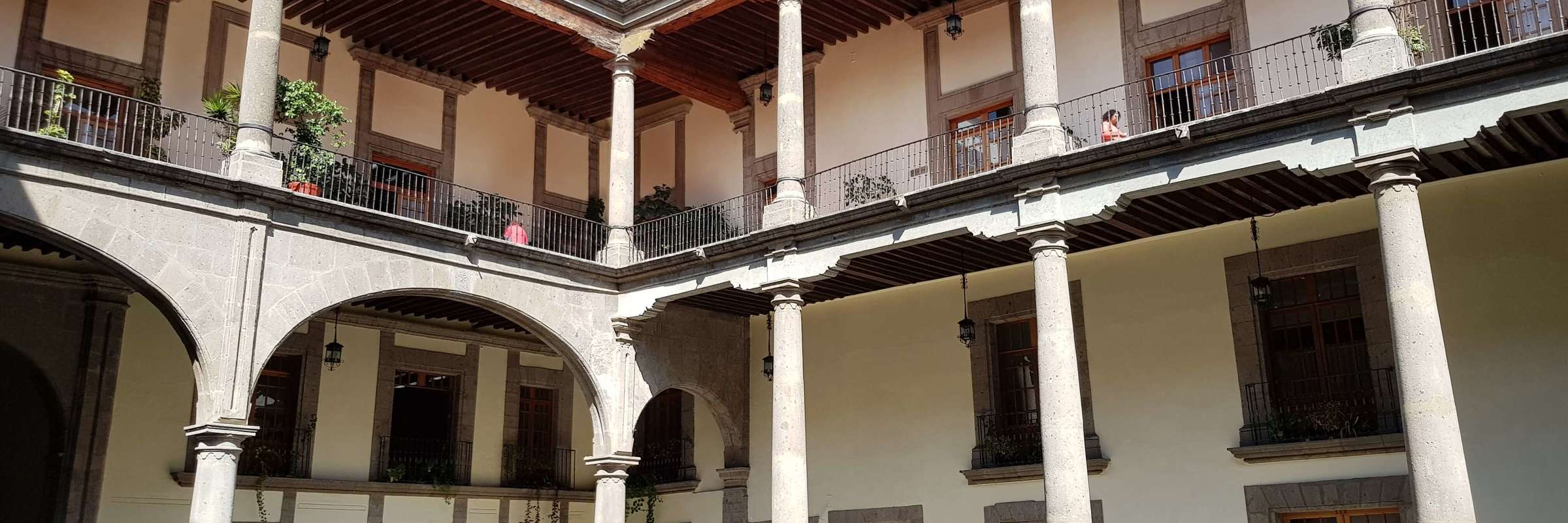 Interior courtyard of the National Palace in Mexico City, with arches, columns, and balconies surrounding the open space. 