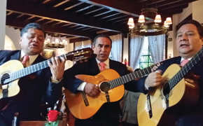 Three traditional Mexican guitarists perform indoors, capturing the spirit and musical heritage of Mexico. 