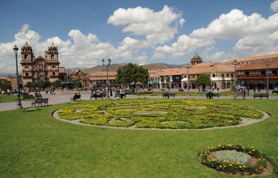 Cusco's Plaza de Armas glows under Andean skies, with vibrant gardens and colonial architecture all around. 