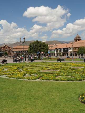 Cusco's Plaza de Armas glows under Andean skies, with vibrant gardens and colonial architecture all around. 