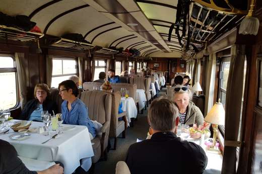 Travelers dining aboard the Andean Explorer luxury train en route through scenic Peru. 