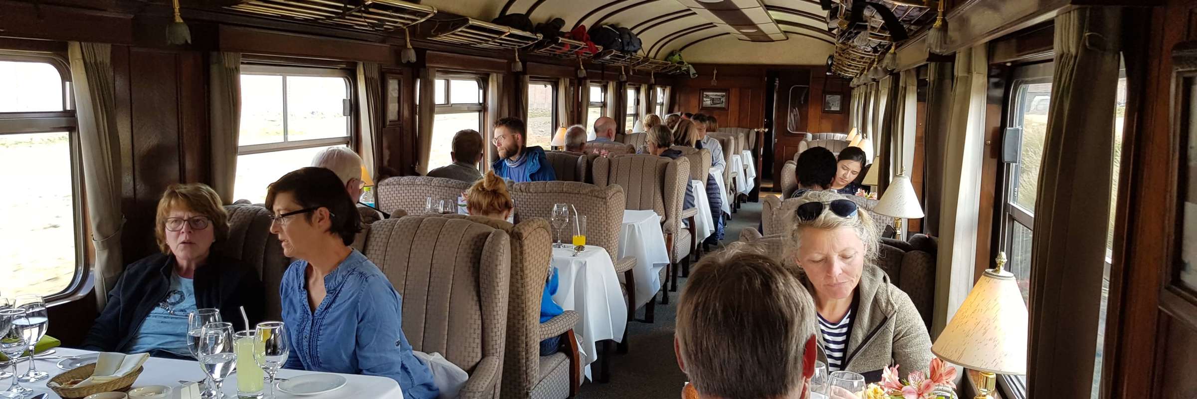 Travelers dining aboard the Andean Explorer luxury train en route through scenic Peru. 