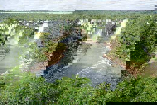 Iguassu Falls thunders through Brazil's rainforest in a sweeping panoramic view. 