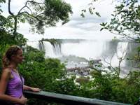 Viewpoint over Iguassu Falls in Brazil, framed by tropical rainforest and mist. 