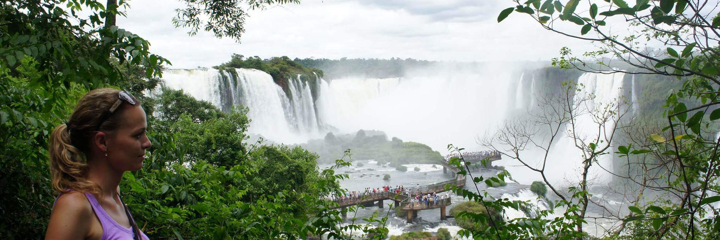 Viewpoint over Iguassu Falls in Brazil, framed by tropical rainforest and mist. 