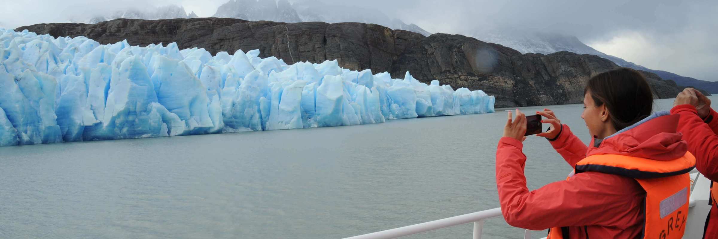 A tourist captures a photo of a brilliant blue glacier from the deck of a boat in Chile's Torres del Paine National Park. 