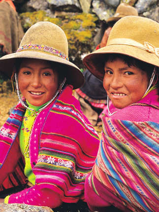 Smiling Peruvian girls in colourful traditional clothing, Sacred Valley Cultural Heritage. 