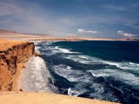View from Mirador La Catedral in Paracas Reserve, with rugged cliffs and waves along Peru's Pacific coast. 