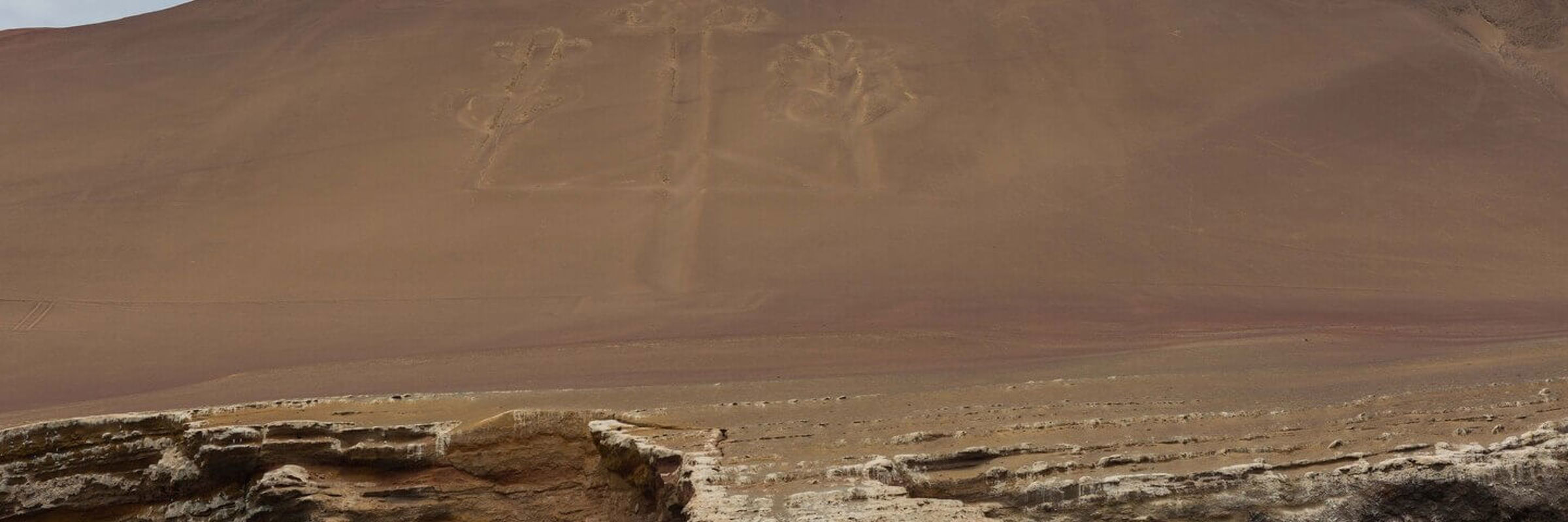 Paracas Candelabra geoglyph etched into the coastal hillside, viewed from the sea near the Ballestas Islands in Peru. 