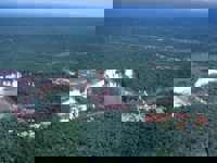 Aerial view of Brazil's Iguassu Falls and rainforest lodges nestled nearby. 