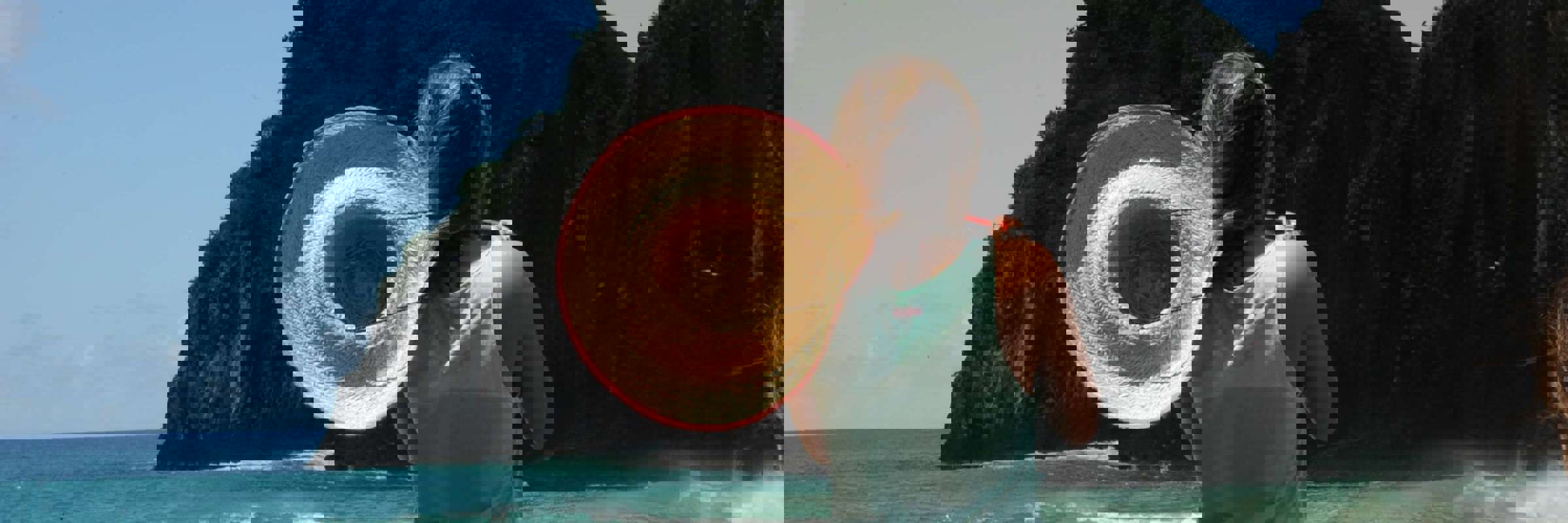 Woman with sunhat overlooks ocean and cliffs at Fernando de Noronha, a stunning island destination in Brazil. 