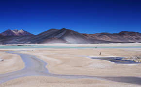 South America - Chile, remote Atacama Desert landscape with salt flats and mountains under blue skies.