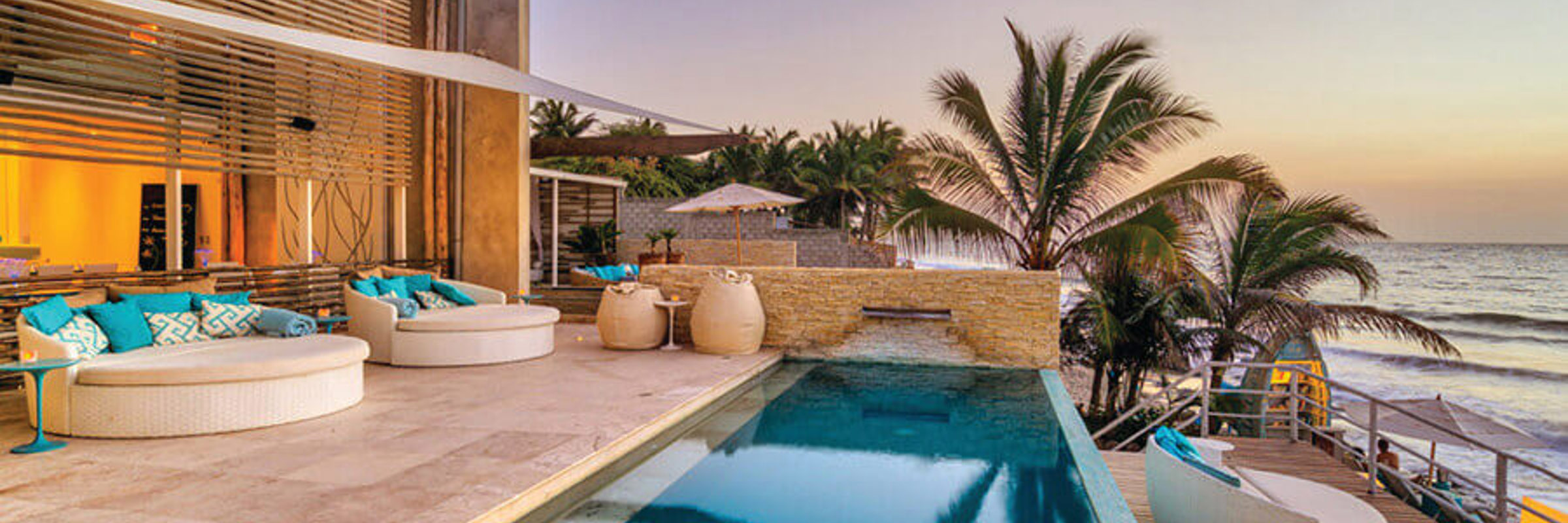 Stylish resort pool and palm-lined terrace overlooking the beach in sunny Mancora, Peru. 