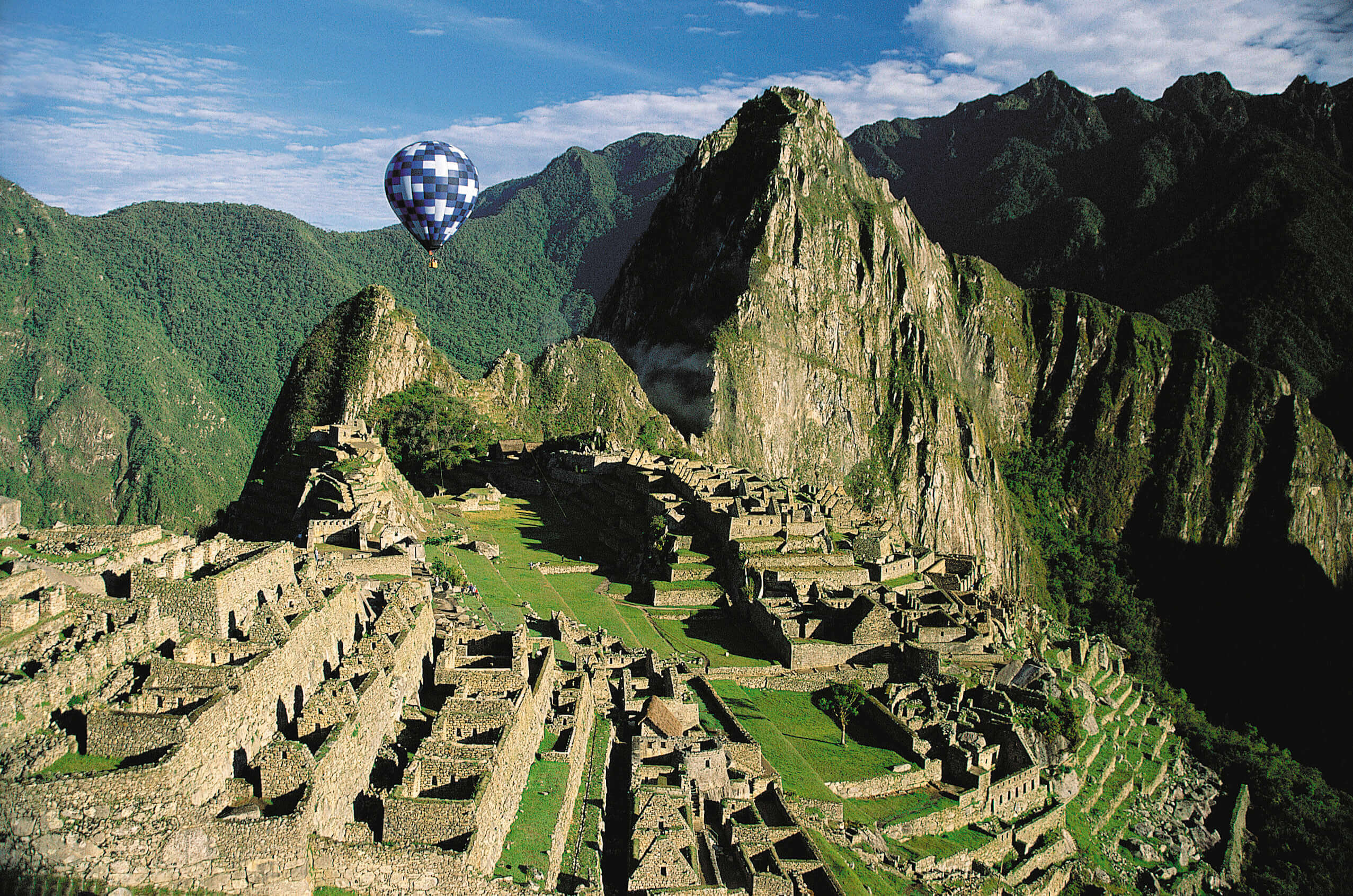 South America - Peru, aerial view of Machu Picchu with a hot air balloon above the Inca citadel. 