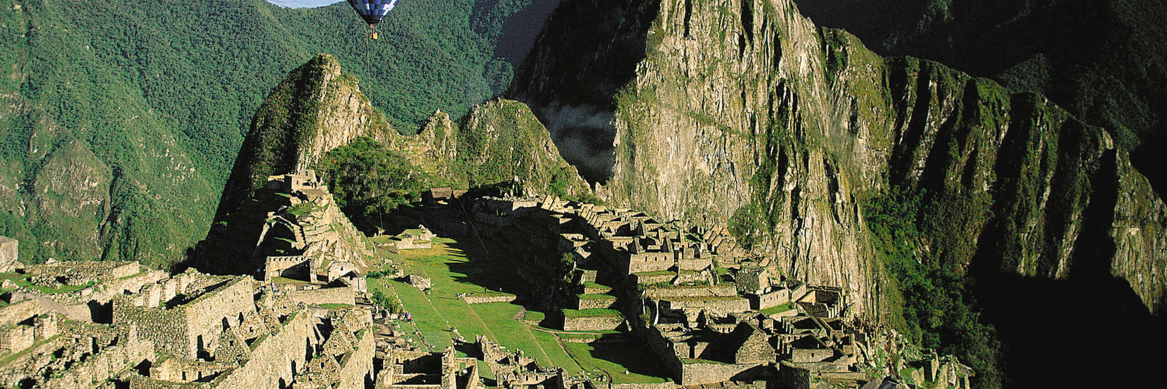 South America - Peru, aerial view of Machu Picchu with a hot air balloon above the Inca citadel. 
