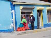 Tarahumara family in traditional dress outside a colourful shopfront in Creel, Copper Canyon, Mexico.