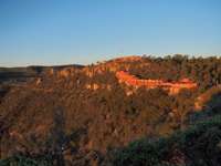 Sunset view of the Posada Barrancas Mirador Hotel overlooking Copper Canyon, surrounded by cliffs and pine forest. 