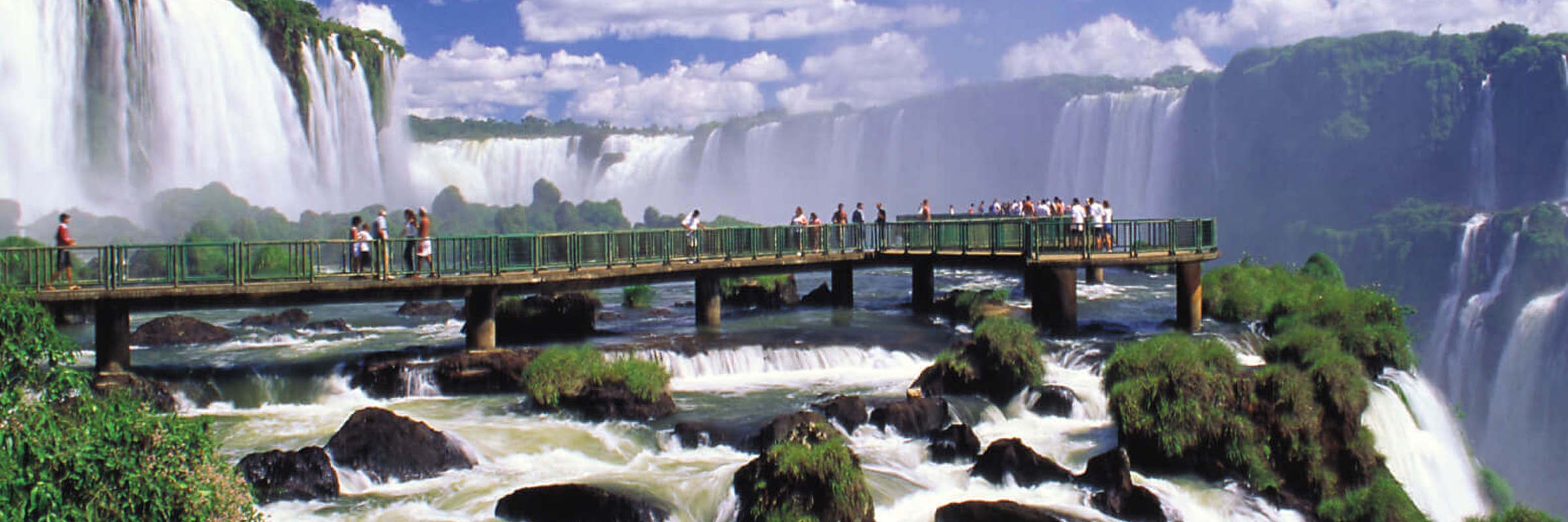 Visitors walk the boardwalk at Iguassu Falls, Brazil, surrounded by thunderous waterfalls. 