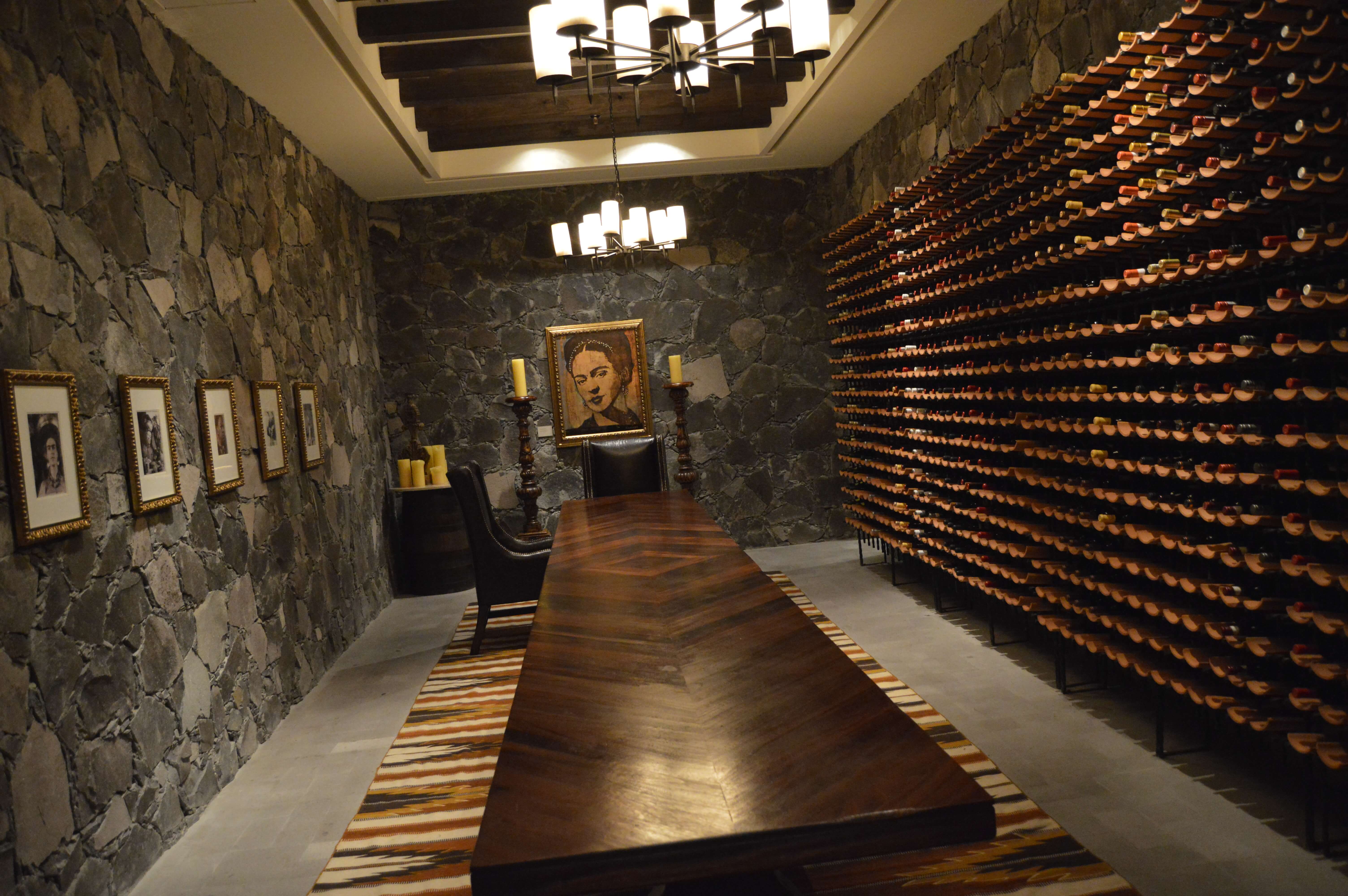 Elegant stone-walled wine cellar with long wooden table and wine racks at a boutique hotel in San Miguel de Allende, Mexico. 