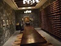 Elegant stone-walled wine cellar with long wooden table and wine racks at a boutique hotel in San Miguel de Allende, Mexico. 