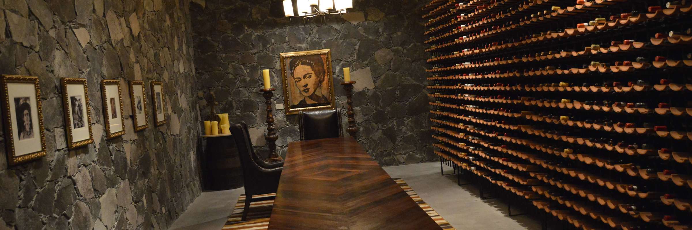 Elegant stone-walled wine cellar with long wooden table and wine racks at a boutique hotel in San Miguel de Allende, Mexico. 