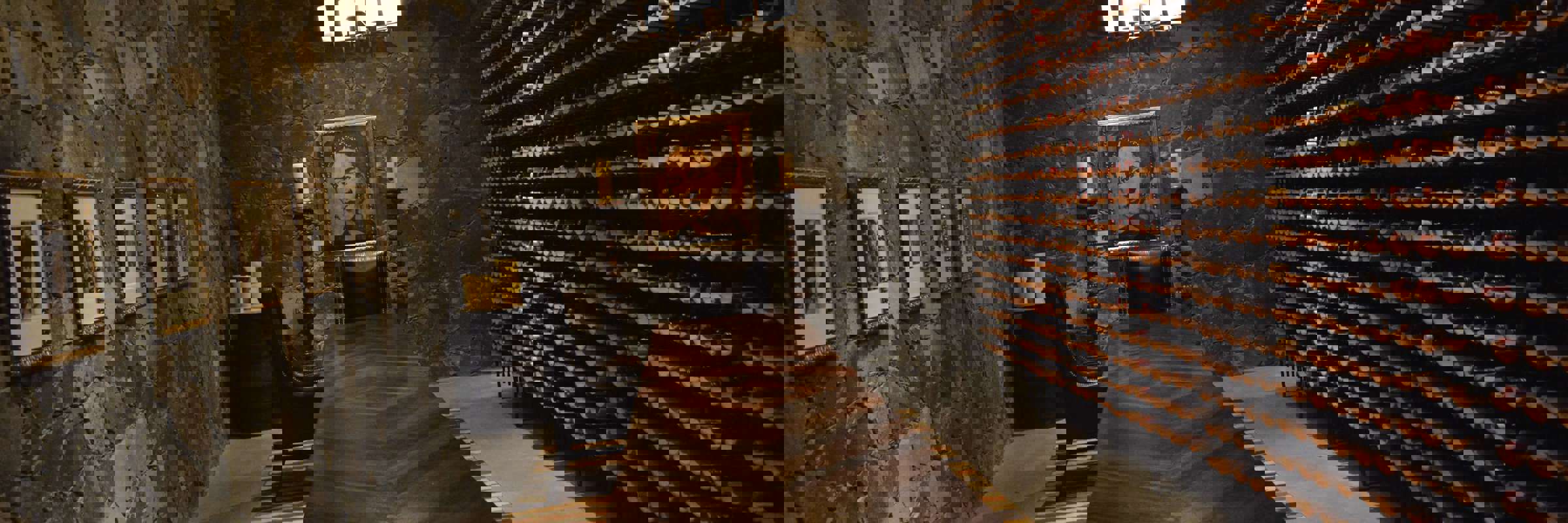Elegant stone-walled wine cellar with long wooden table and wine racks at a boutique hotel in San Miguel de Allende, Mexico. 