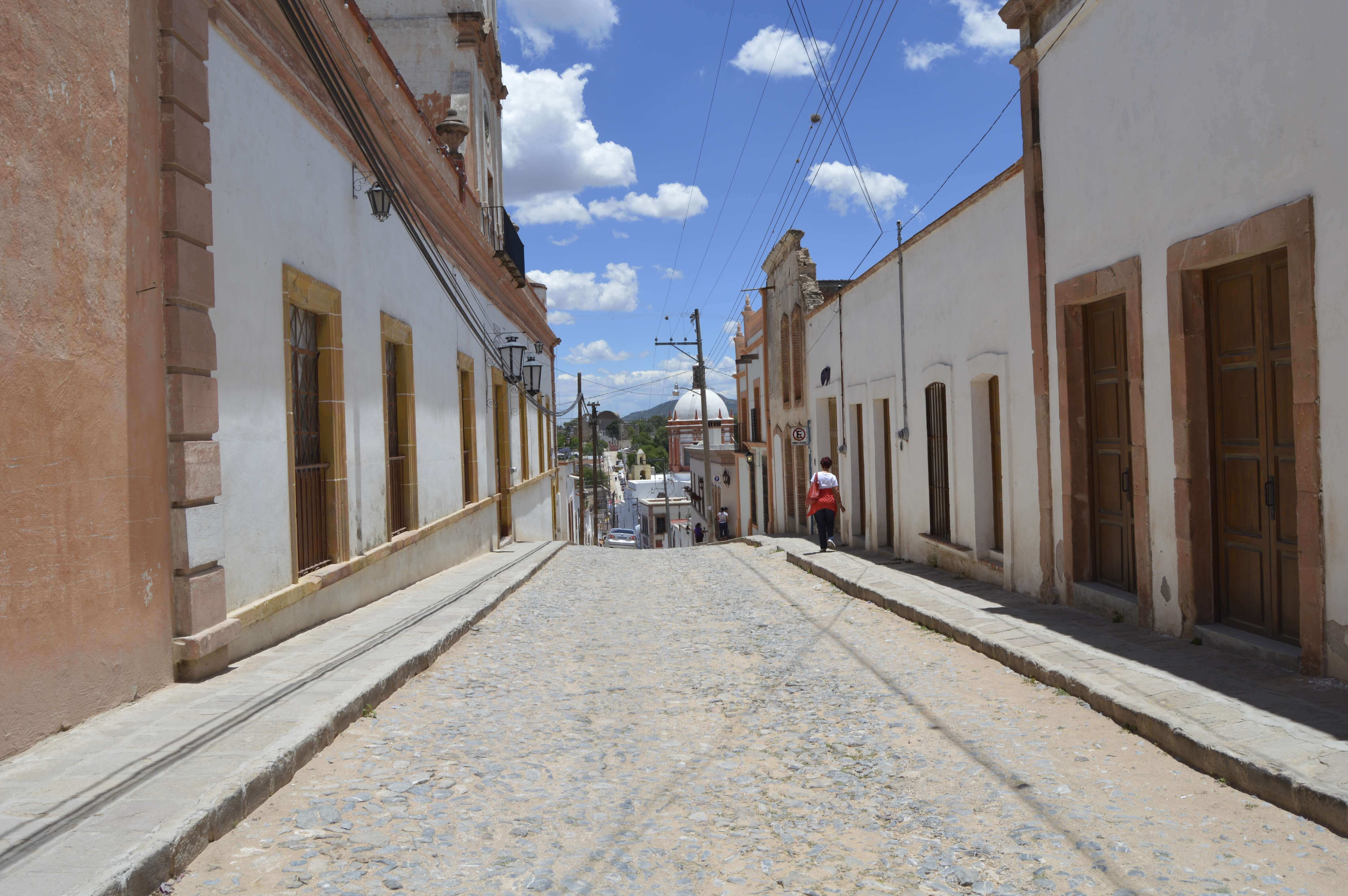 Charming cobblestone street lined with colonial buildings in San Miguel de Allende, Mexico. 