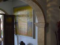 Rustic stone archway with wooden door, jar, and patterned lighting inside a boutique hotel in San Miguel de Allende, Mexico. 