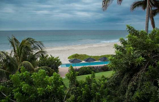 Tropical palms frame serene ocean waves at Kichic's peaceful beachfront hideaway in Mancora. 