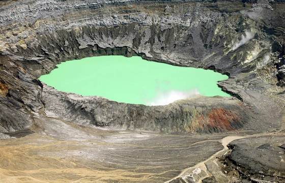 A surreal green crater lake fills the vast bowl of Poas Volcano, showcasing Costa Rica's raw power. 