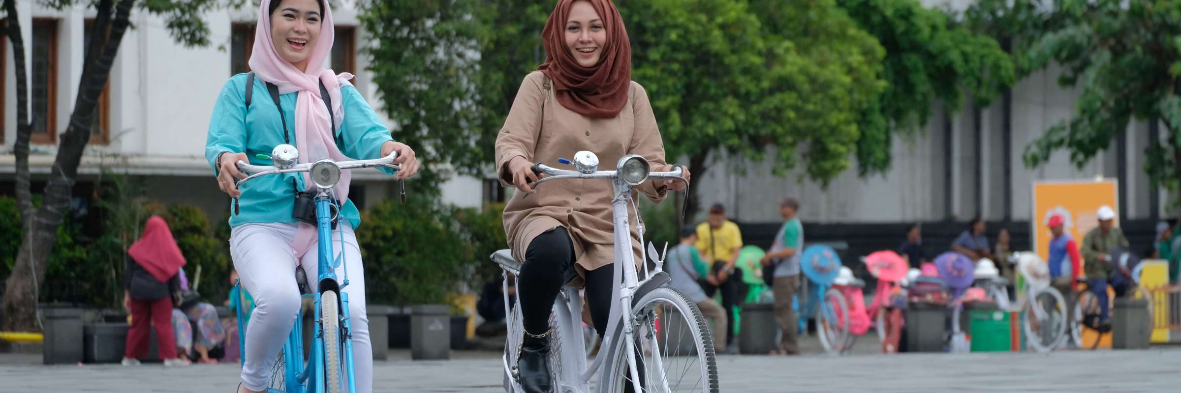 Women enjoying cycling in Jakarta's Old Town, promoting inclusive tourism experience in Indonesia's capital. 