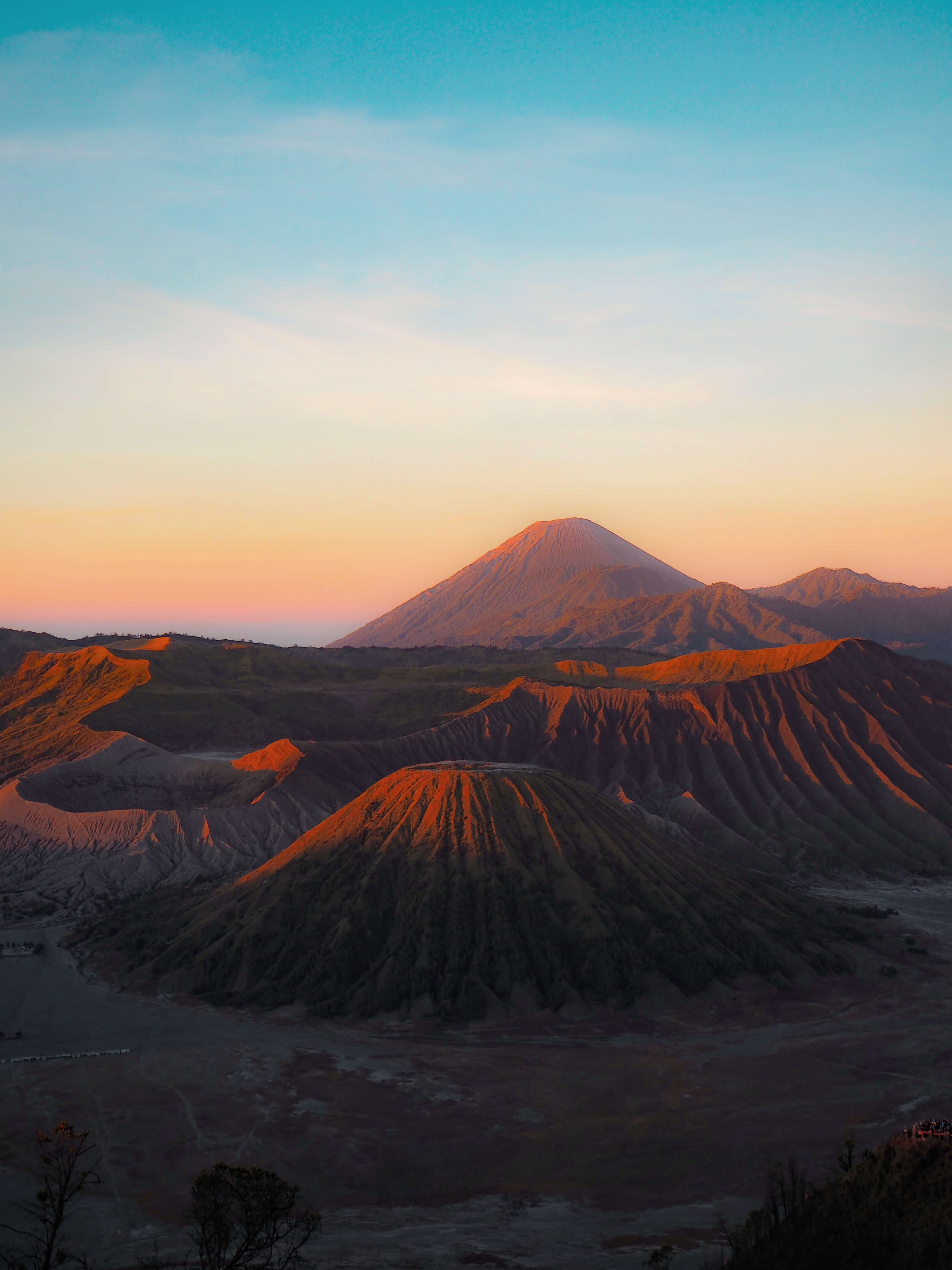 Mount Bromo and surrounding caldera at sunrise in East Java, Indonesia, with soft morning light and volcanic landscape. 