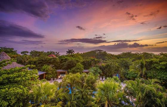 Sunset sky over Cala Luna resort surrounded by lush greenery in Costa Rica. 