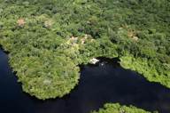 Aerial view of Cristalino Jungle Lodge surrounded by dense Amazon rainforest and winding blackwater river in Brazil. 