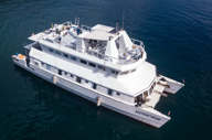 Aerial view of the Enterprise catamaran cruising the waters off Brazil, showcasing its modern design and spacious deck. 