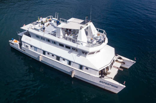 Aerial view of the Enterprise catamaran cruising the waters off Brazil, showcasing its modern design and spacious deck. 